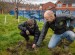 A student planting a tree with a member of the Mersey Forest team.